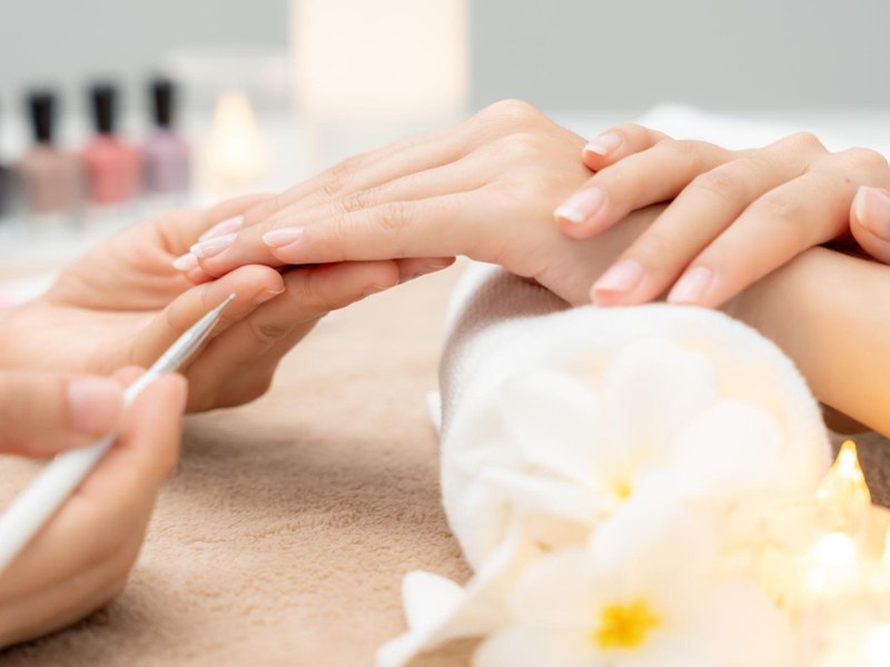 A guest receiving a professional manicure and hand treatment with spa accessories